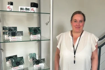A lady standing next to shelves of computer vision products
