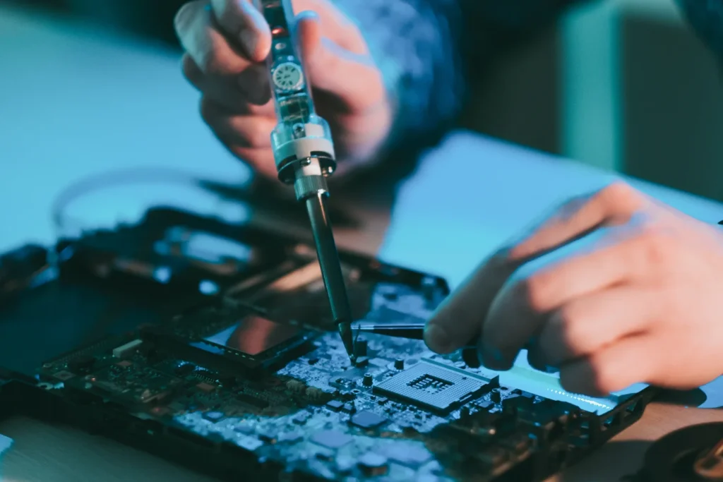 A person using a tool to fix a pcb