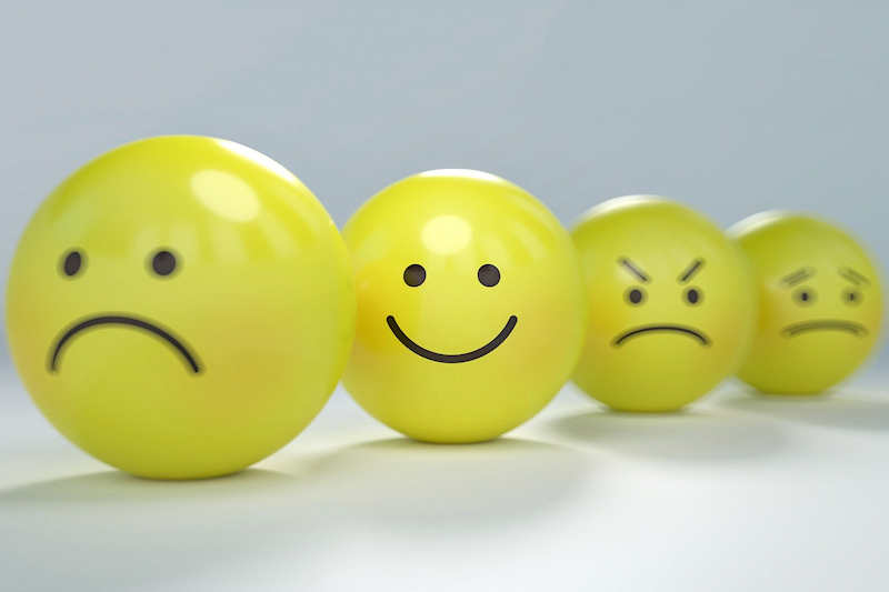 Yellow balls lined up with faces drawn on displaying different emotions