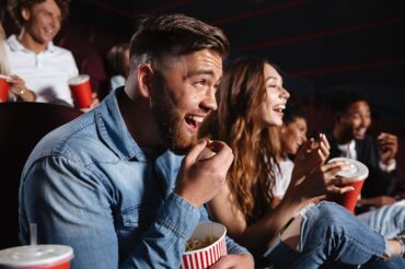 Image of laughing friends sitting in cinema