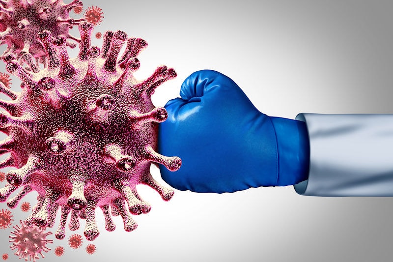 Covid-19 virus being hit by a doctor wearing a boxing glove