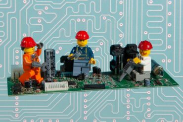 Lego figures fixing a PCB