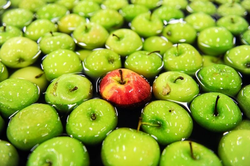 One red apple among many green apples