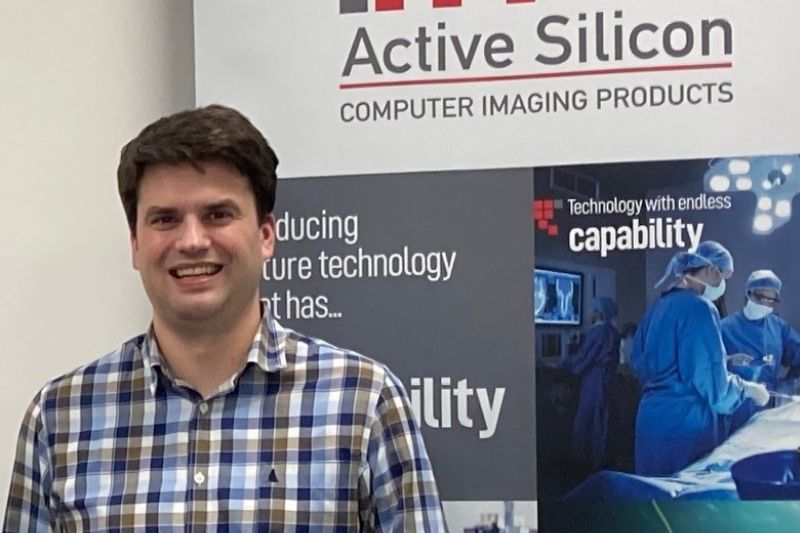 Engineer standing in front of a company banner