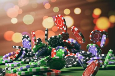 colored casino chips falling onto a roulette table