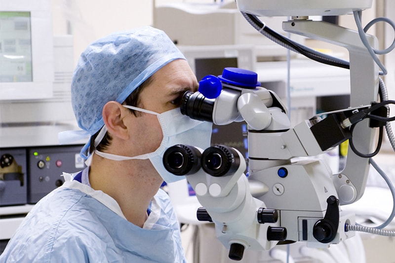 Surgeon at a medical microscope during an operation