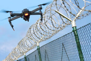 a drone flying near a barbed wire fence