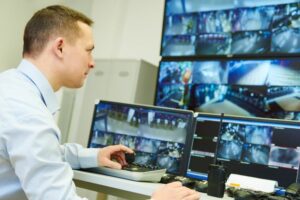 Security officer looking at several CCTV screens