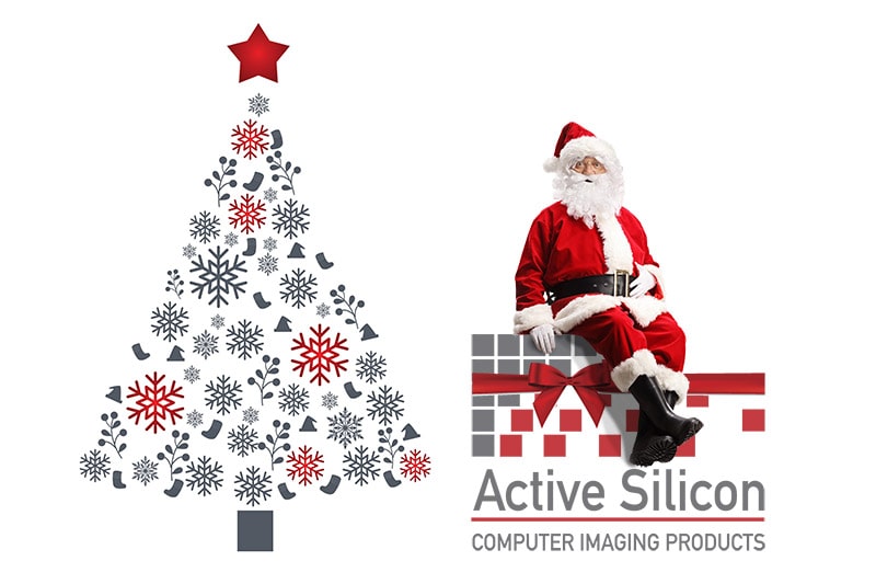 Santa sitting on the Active Silicon logo next to a christmas tree