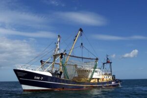 A fishing boat with its nets above water