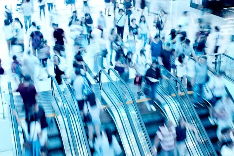 Fast-moving shoppers on an escalator in a shopping mall