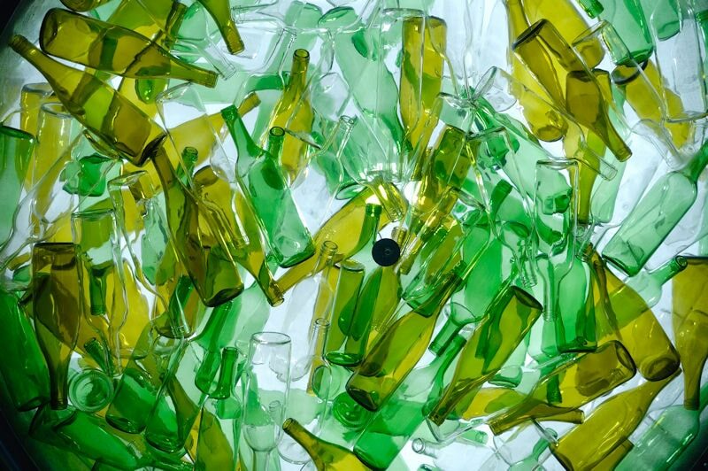 lots of glass bottles in different shades of green and clear glass.